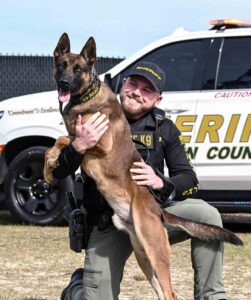 Walton County Sheriff’s Office K-9 Aries with handler posing in front of patrol vehicle