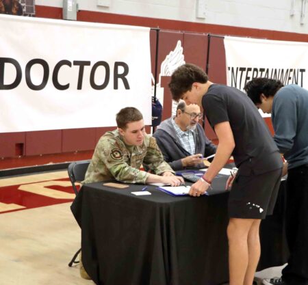 Niceville High School students review financial paperwork at Reality Check simulation booth