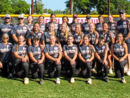 Niceville High School Lady Eagles softball team poses in custom military appreciation jerseys on the field
