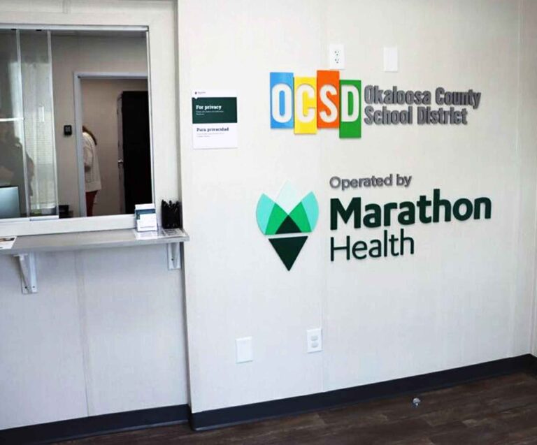New clinic gives OCSD staff no-cost care access Interior of the OCSD employee health clinic showing signage for Okaloosa County School District and Marathon Health