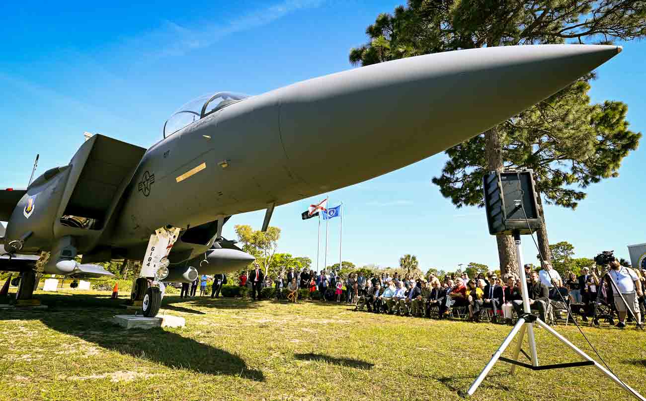 Crowd gathers for a dedication ceremony beside an F-15E Strike Eagle at the Air Force Armament Museum
