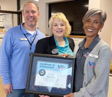 Eglin Federal Credit Union employee Suyen Berezo receives a 25-year service award alongside coworkers