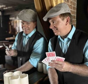 Magician Jeff Sobel performs a card trick while holding a fan of playing cards.