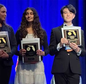 Students on stage holding awards at the State Science and Engineering Fair in Florida