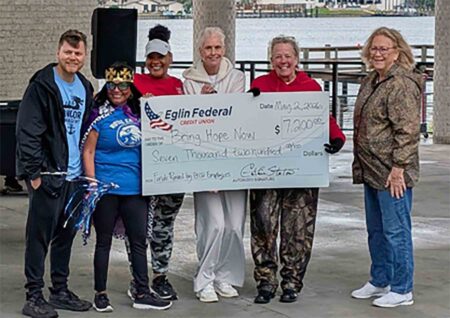 Representatives from Eglin Federal Credit Union pose with a ceremonial check for Bring Hope Now during a waterfront community event in Fort Walton Beach.