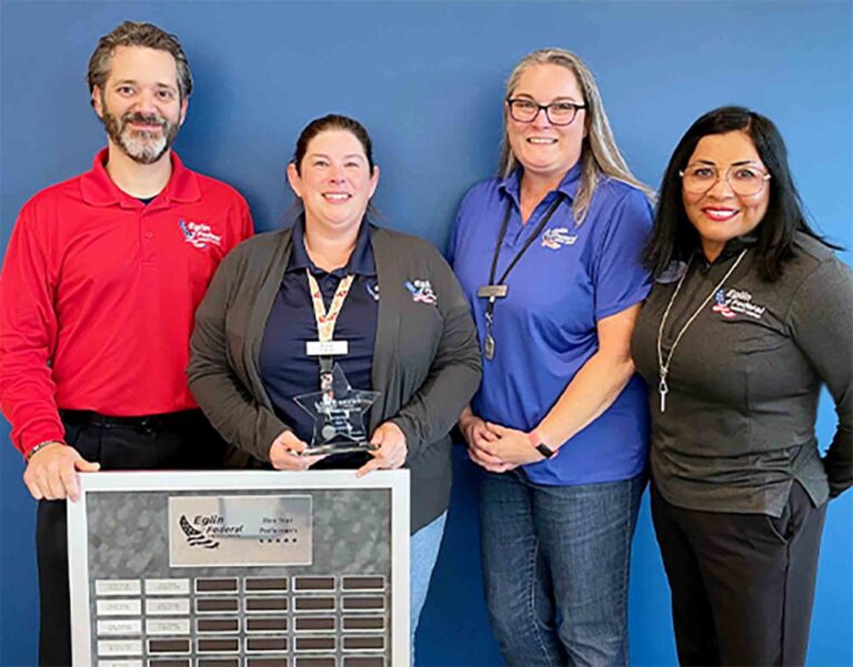 Four Eglin Federal Credit Union employees stand together as Erica Hennion holds the Five-Star Performer Award plaque.