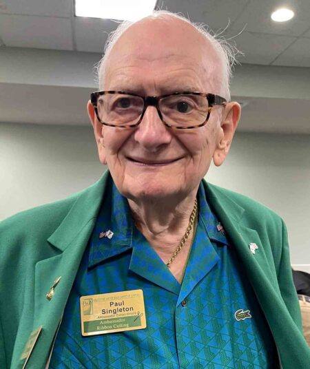 Paul Singleton, a longtime Greater Fort Walton Beach Chamber of Commerce ambassador, poses for a portrait while wearing his Chamber ambassador badge and green blazer. He is being recognized for attending his 2,000th Chamber event. (Contributed)