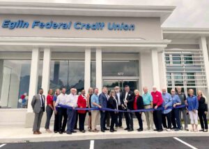 Community leaders, Eglin Federal Credit Union officials, and employees gather outside the new DeFuniak Springs branch during a ribbon-cutting ceremony marking the facility's grand opening.