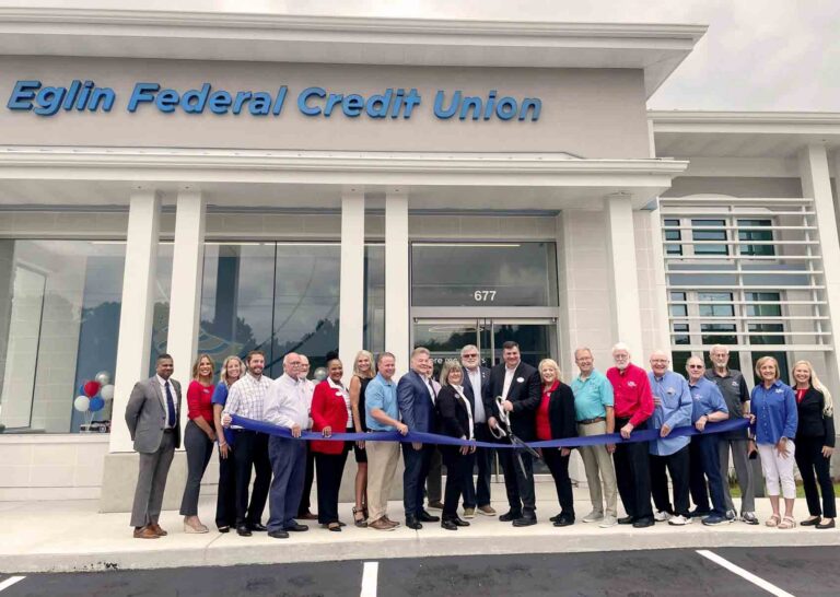 Community leaders, Eglin Federal Credit Union officials, and employees gather outside the new DeFuniak Springs branch during a ribbon-cutting ceremony marking the facility's grand opening.