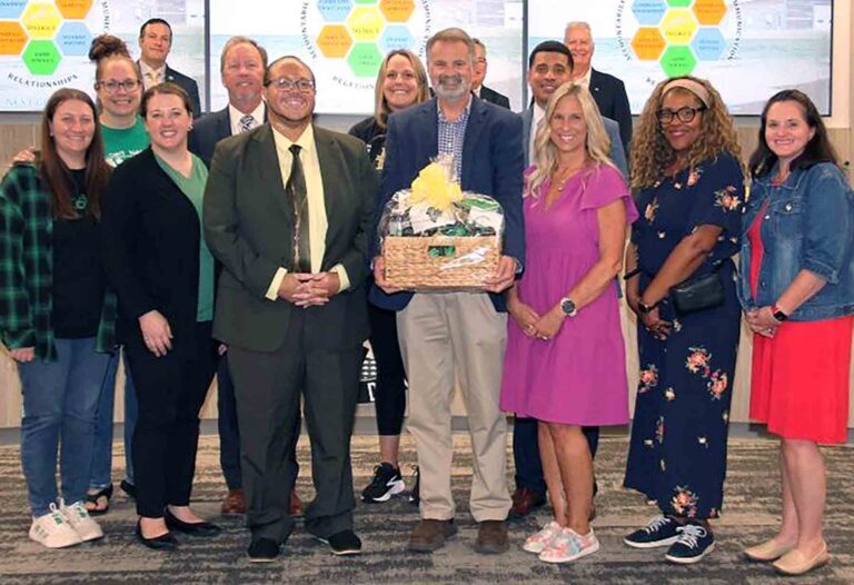 Craig Kinsley stands with Okaloosa County School District leaders and colleagues after being named assistant principal of Lewis School.