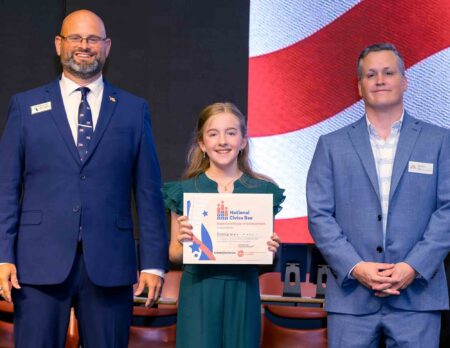 Three local students represent region at Civics Bee state finals National Civics Bee state finalist Emma C. holds her State Certificate of Achievement while posing with two state Civics Bee officials.