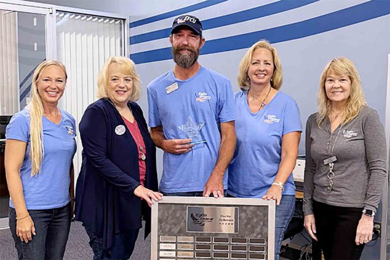 Facilities/Procurement Specialist Andrew Funk stands with Eglin Federal Credit Union employees after being recognized as the credit union's Five-Star Performer for the second quarter of 2026. Mr Funk holds his award while colleagues gather around the Five-Star Performer recognition plaque.