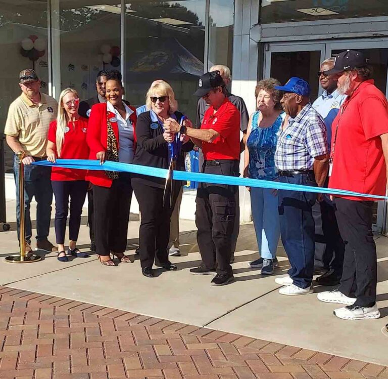 Community leaders and Eglin Federal Credit Union representatives cut a blue ribbon during the opening celebration for the Eglin Federal Credit Union Arts and Education Center in downtown Crestview.